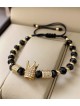 Bratara dama model deosebit cu margele aurii si negre si coroana cu pietricele albe
