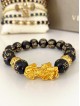 Bratara dama model deosebit cu margele negre si detalii aurii